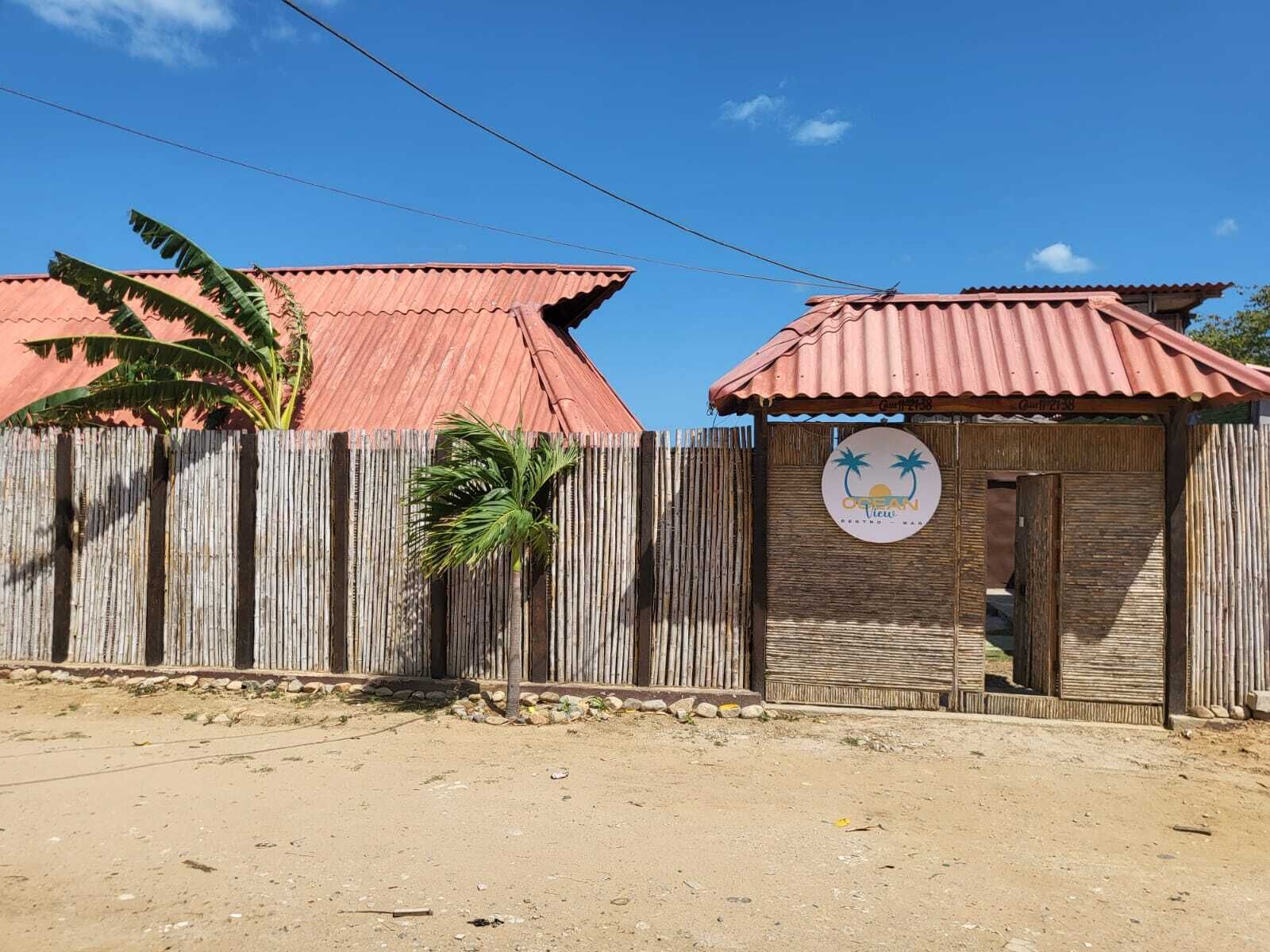 Une propriété clôturée avec un petit bâtiment sur lequel est apposée une enseigne indiquant : « Ocean View Resort & Spa ».