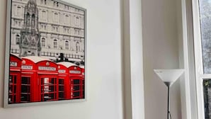 A framed picture of red telephone booths on a white wall. - Apartment Sleeps 7 With Wifi (London)