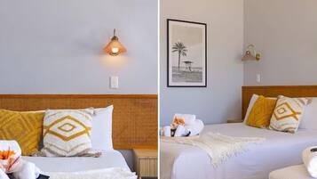 A hotel room with a bed, a nightstand, a wall-mounted lamp, and a framed picture.