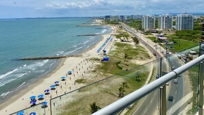 Un paysage urbain côtier avec une plage, une route et des immeubles de grande hauteur.