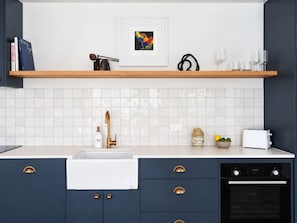 A modern kitchen with a white sink, a coffee machine, and a toaster.