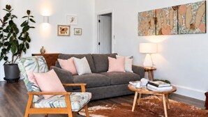 A spacious living room with a grey sofa, a wooden chair, a round coffee table, and a large abstract painting on the wall. - Shawwood Barrel Room Luxury Mudgee Farm Stay, close to town and wineries (Bombira)