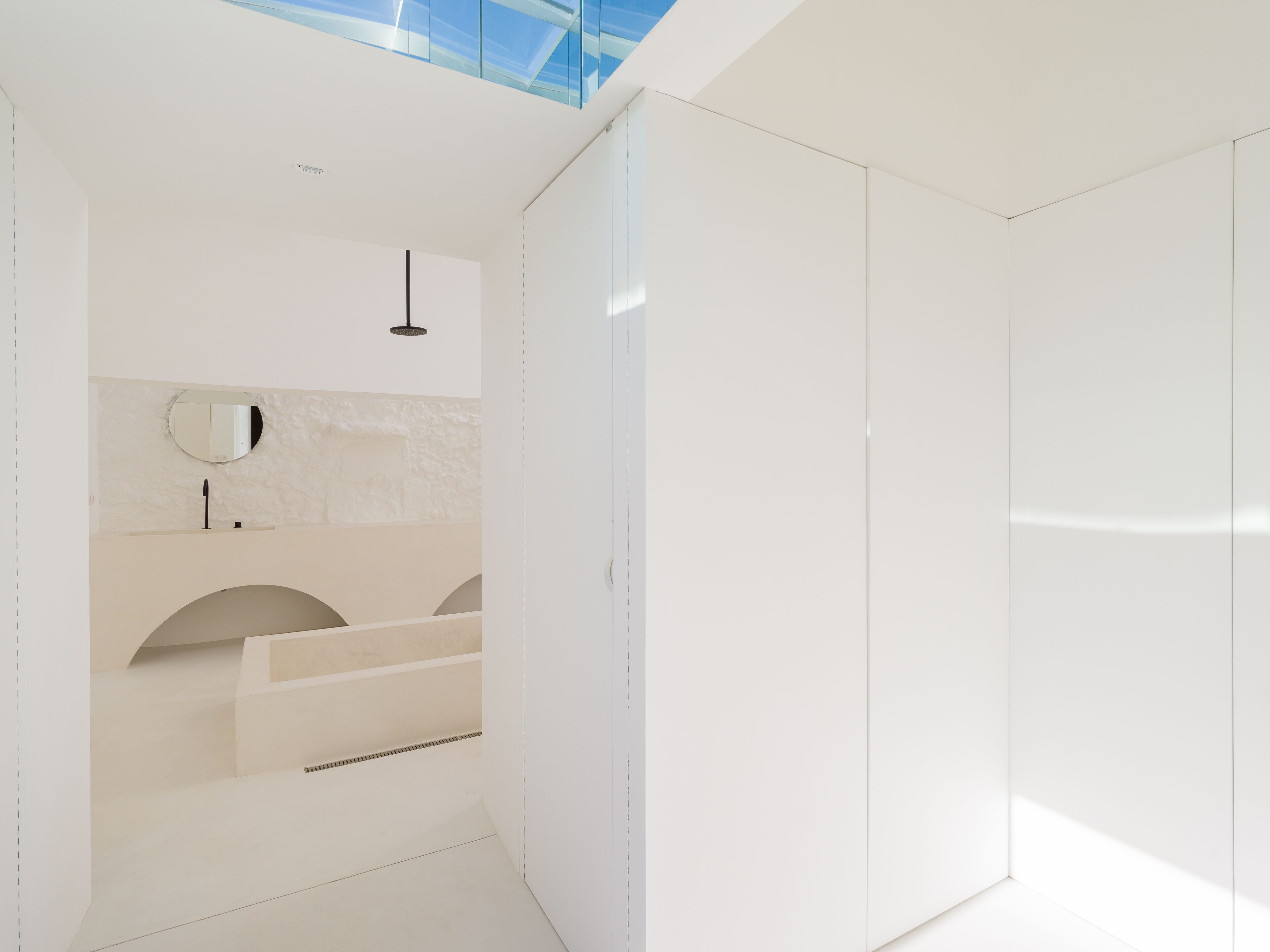 Une salle de bain moderne avec une lucarne, un miroir et un lavabo.