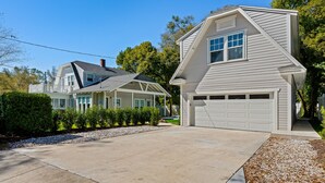 Ein zweistöckiges Haus mit Garage, überdachter Veranda und Auffahrt.