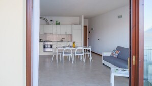 Un apartament modern amb zona de menjador, cuina i saló.