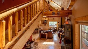 A wooden staircase leading to a living area with a sofa, coffee table, and bookshelves. - Beautiful, Cozy and Quiet Home Nestled in an Aspen Grove (Jefferson)