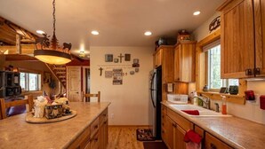A kitchen with wooden cabinets, a refrigerator, and a wooden countertop. - Beautiful, Cozy and Quiet Home Nestled in an Aspen Grove (Jefferson)