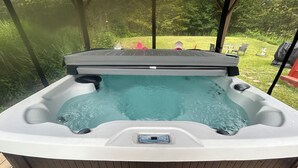 A hot tub with a wooden exterior and a control panel at the front.