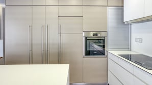 Una cuina moderna amb electrodomèstics d'acer inoxidable, forn integrat i un taulell elegant.