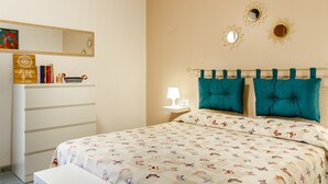 A bedroom with a bed, a dresser, a mirror, and wall decorations. - Apartment 'Casa Montecristo' with Air Conditioning, 50 Meters from the Sea (Castiglione della Pescaia)