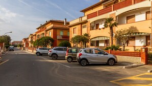 A residential street with parked cars and multi-story buildings. - Apartment 'Casa Montecristo' with Air Conditioning, 50 Meters from the Sea (Castiglione della Pescaia)