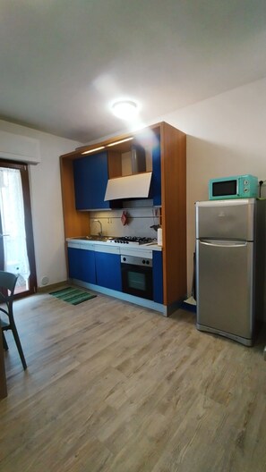 A kitchen with a stove, oven, microwave, and refrigerator.