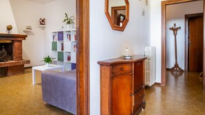 Una habitación con chimenea, estantería, espejo y radiador.
