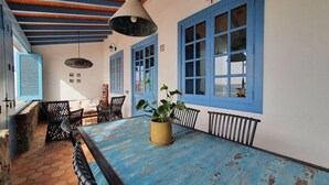 A dining area with a blue table, black chairs, and a hanging light fixture. - Vacation Villa 'Delicias' with Sea View, Private Terrace and Wi-Fi (Taliarte)