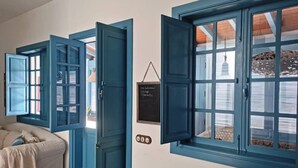 A room with a large window, a door, a small table, and a chair. - Vacation Villa 'Delicias' with Sea View, Private Terrace and Wi-Fi (Taliarte)