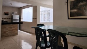 Una cocina moderna con refrigerador empotrado, una mesa de comedor con sillas y un ventanal que proporciona luz natural.