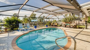 Ein überdachter Außenpool mit Liegestühlen und einer Terrassenfläche.