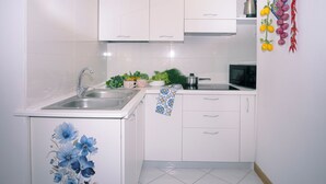 A kitchen with white cabinets, a sink, and a stove. There is a sign above the cabinets that reads "FORTUNA HOUSE." - De Vivo Realty - Fortuna House (Sant'Agnello)