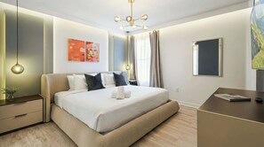A modern hotel room with a large bed, bedside tables, a desk, and a TV. - Lakeview Storey Lake | Minions, Avengers & Mario (Kissimmee)