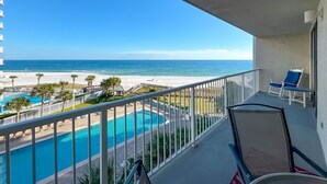 A balcony with a view of a beach and a swimming pool. - BEACHFRONT, TWO POOLS, PRIVATE BALCONY! (Orange Beach)