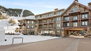 Un hôtel à plusieurs étages avec une piste de ski en arrière-plan.