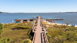 A wooden boardwalk leading to a dock with boats and a clear view of the water. - Windswept Dr  Condo in a quiet, golf course community close to Rehoboth Beach (Millsboro)