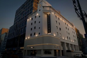 A modern hotel with a prominent entrance, multiple floors, and illuminated windows. - Anook Hotel Suwon Ingye (Suwon)