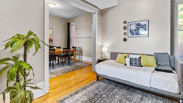 A modern living room with a sofa, a dining area with a table and chairs, and a large plant. - Mesaba Lake Superior View Condo, Heirloom Vacations (Duluth)