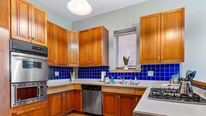 A kitchen with wooden cabinets, a built-in oven, a dishwasher, and a gas stove. - Mesaba Lake Superior View Condo, Heirloom Vacations (Duluth)