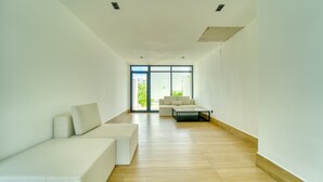 A spacious living room with a large window, a sofa, and a coffee table. - Downtown Punta Cana, Republica Dominicana.

 (Punta Cana)