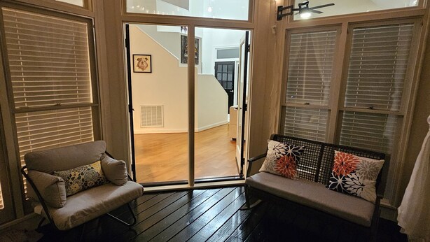 A cozy room with a ceiling fan, a bench with cushions, and a view of a staircase. - Private Raleigh Bungalow Retreat near Downtown Raleigh (Raleigh)