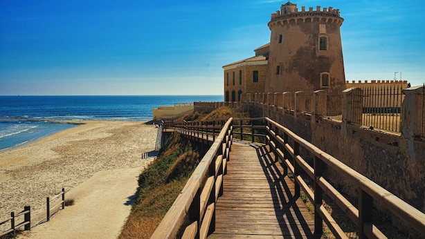 A coastal building with a wooden walkway leading to the beach. - Casa Velazquez (Ciudad Quesada) (Rojales)