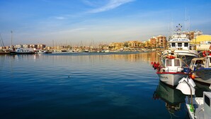 A marina with boats docked, calm water, and a cityscape in the background. - Casa Velazquez (Ciudad Quesada) (Rojales)