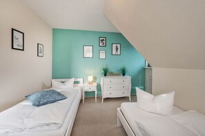 Ein Schlafzimmer mit zwei Betten, einem Schminktisch und einem Nachttisch.