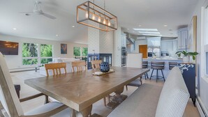 Una cocina moderna con una mesa de comedor de madera, taburetes de bar y un horno empotrado.