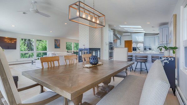 Una cocina moderna con una mesa de comedor de madera, taburetes de bar y un horno empotrado.
