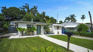 A residential property with a well-maintained lawn, a mailbox, and a small front yard with plants.