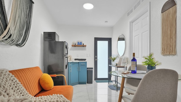 A compact living space with a sofa, a dining table, and a kitchenette.