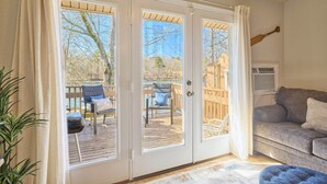 Ein Zimmer mit einer Schiebetür und Zugang zu einer Terrasse mit Stühlen und einem Tisch.
