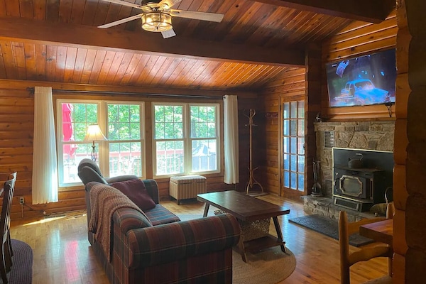 Open concept living room with wood burning fireplace and TV with ROKU.
