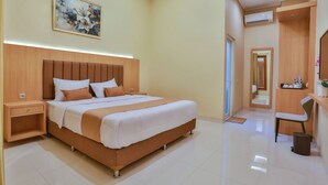 Een moderne hotelkamer met een groot bed, nachtkastjes, een bureau en een spiegel.