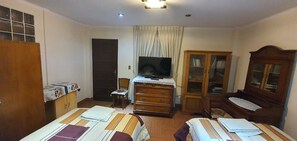 Two single beds with striped bedding, a wardrobe, and a cabinet with glass doors.