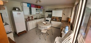 Prepare meals and dine in this kitchen with a central island, refrigerator, stove, sink, and ample storage.