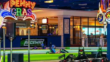 Una pista de carreras de karts con letreros de neón, incluyendo 'Penny Gra' y 'Raceway'.