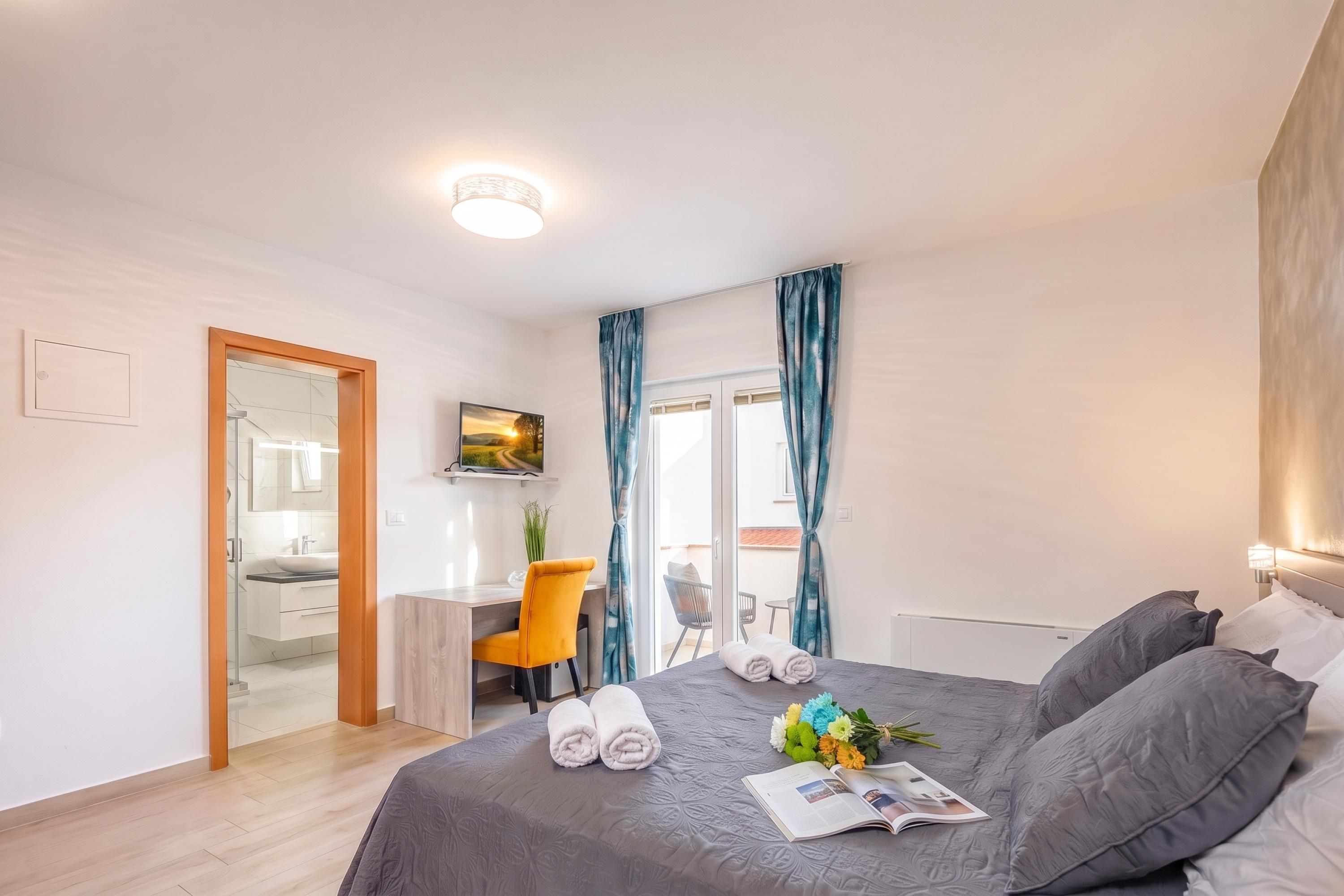 Een moderne slaapkamer met een bed, een bureau en een stoel.