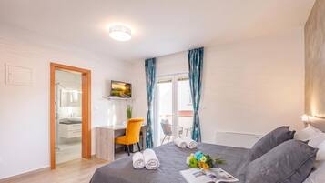 Een moderne slaapkamer met een bed, een bureau en een stoel.