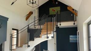 A modern staircase with a metal railing, wooden steps, and a white wall. - Ferienhaus Inselglück in der Puddeminer Wiek (Poseritz)