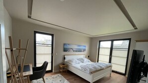 A bedroom with a bed, a desk, a chair, and a TV. - Ferienhaus Inselglück in der Puddeminer Wiek (Poseritz)