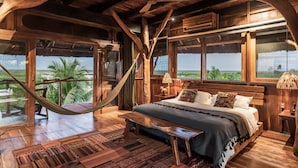 Un dormitorio de madera con cama, banco y hamaca.
