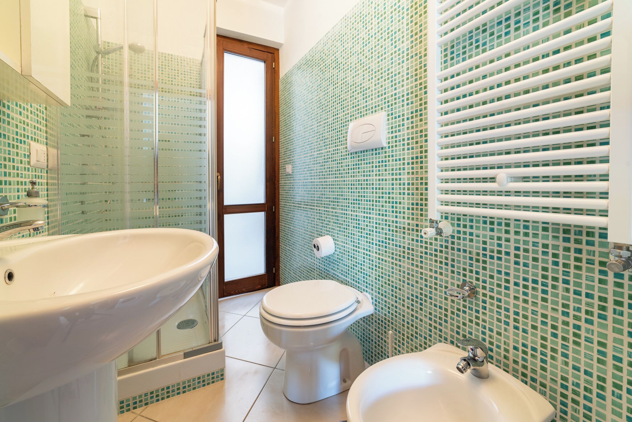 Une salle de bain équipée d’un lavabo, de toilettes et d’un bidet.